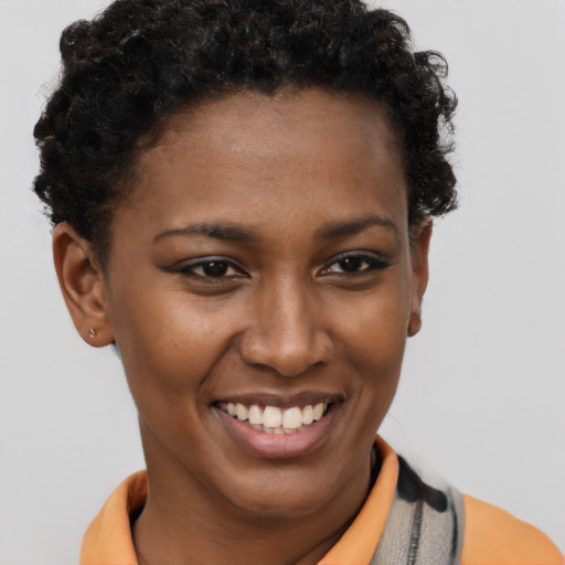 Joyful black young-adult female with short  brown hair and brown eyes
