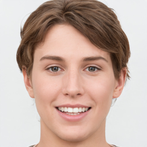 Joyful white young-adult female with short  brown hair and grey eyes