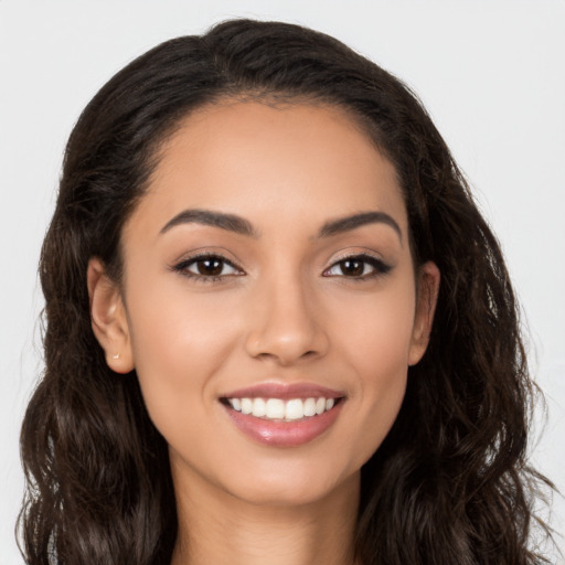 Joyful latino young-adult female with long  brown hair and brown eyes