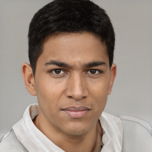 Joyful latino young-adult male with short  brown hair and brown eyes