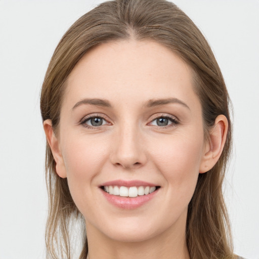 Joyful white young-adult female with long  brown hair and grey eyes