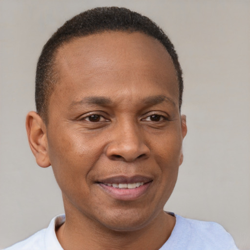 Joyful black adult male with short  brown hair and brown eyes