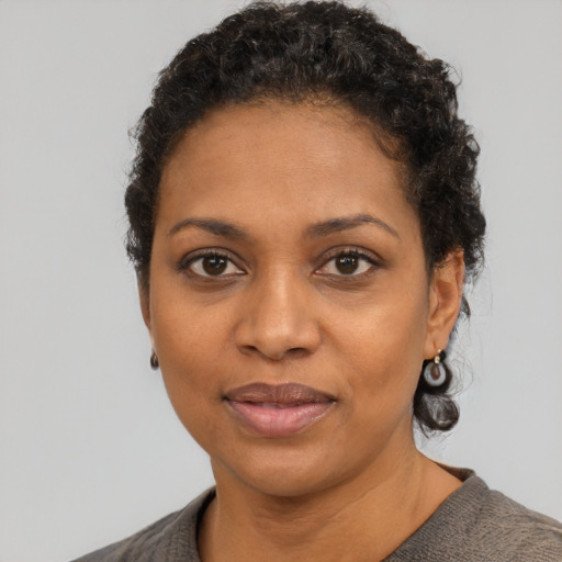 Joyful black adult female with short  black hair and brown eyes