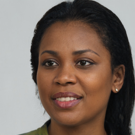 Joyful black young-adult female with long  black hair and brown eyes