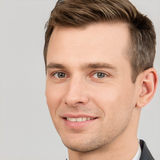 Joyful white young-adult male with short  brown hair and grey eyes