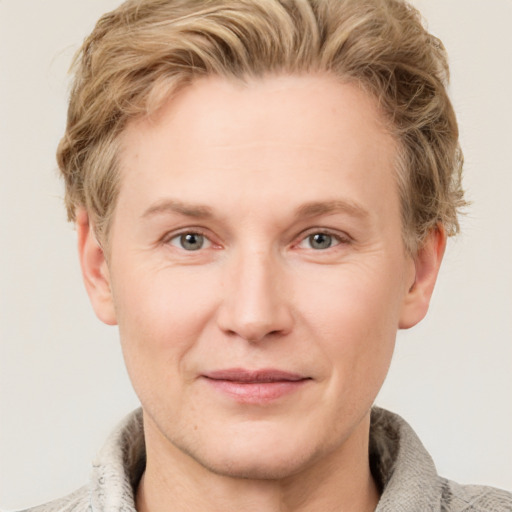 Joyful white young-adult male with short  brown hair and blue eyes