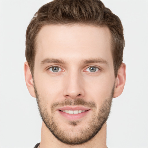 Joyful white young-adult male with short  brown hair and grey eyes