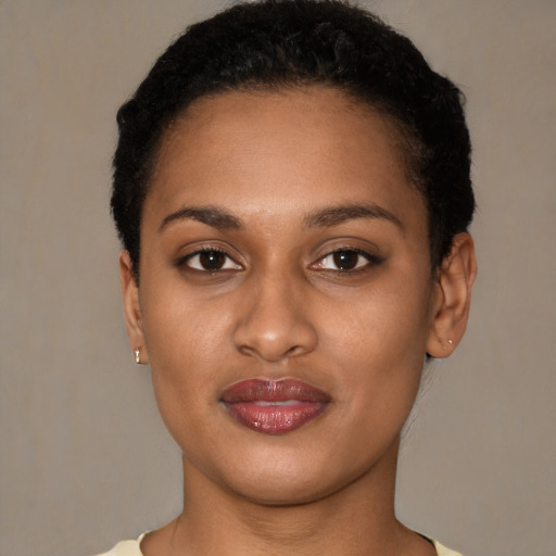 Joyful black young-adult female with short  black hair and brown eyes