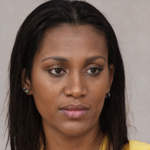 Joyful black young-adult female with long  brown hair and brown eyes