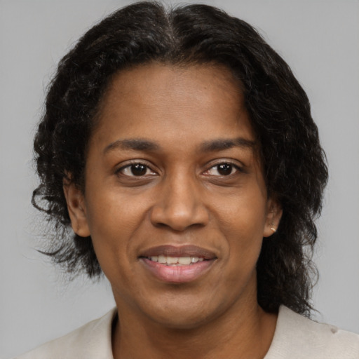 Joyful black adult female with medium  brown hair and brown eyes