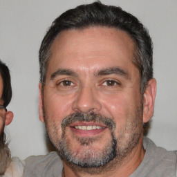 Joyful white adult male with short  black hair and brown eyes