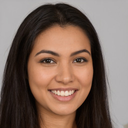 Joyful latino young-adult female with long  brown hair and brown eyes