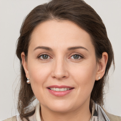 Joyful white young-adult female with medium  brown hair and grey eyes