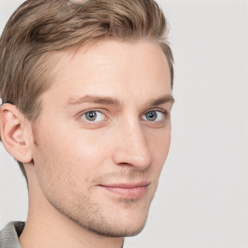 Joyful white young-adult male with short  brown hair and grey eyes