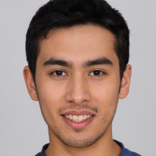 Joyful latino young-adult male with short  brown hair and brown eyes