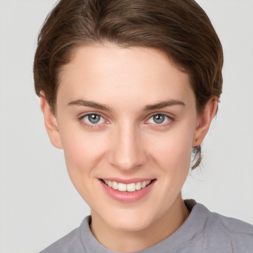 Joyful white young-adult female with short  brown hair and grey eyes