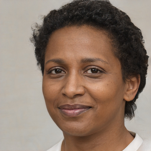 Joyful black adult female with short  brown hair and brown eyes