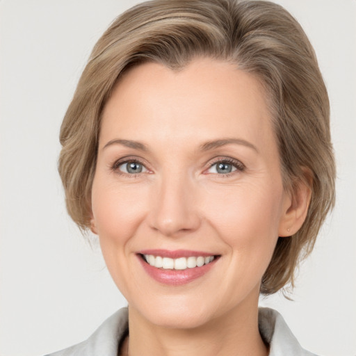 Joyful white adult female with medium  brown hair and grey eyes