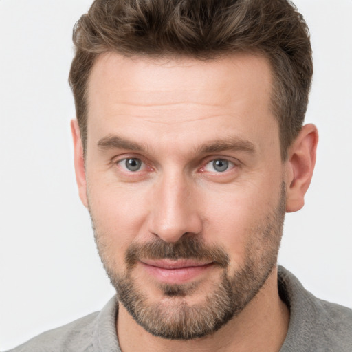 Joyful white adult male with short  brown hair and grey eyes