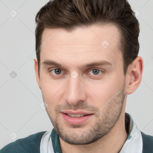 Joyful white young-adult male with short  brown hair and grey eyes