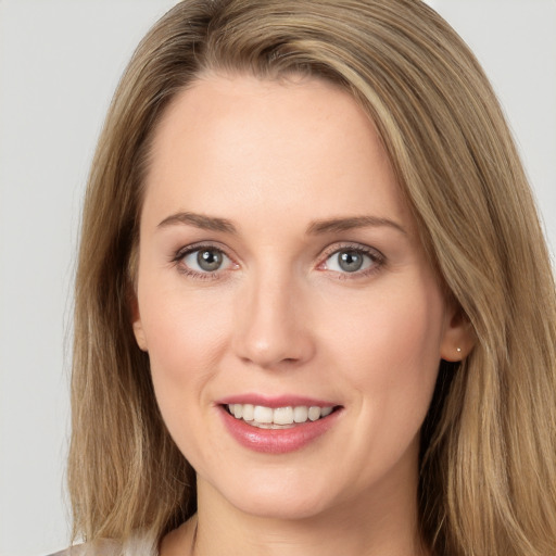 Joyful white young-adult female with long  brown hair and grey eyes