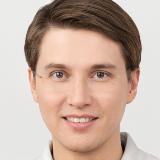 Joyful white young-adult male with short  brown hair and grey eyes