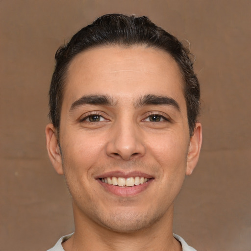 Joyful white young-adult male with short  brown hair and brown eyes