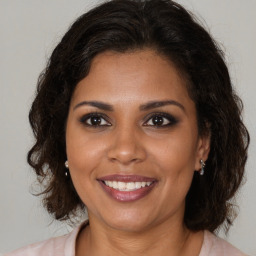 Joyful black young-adult female with medium  brown hair and brown eyes