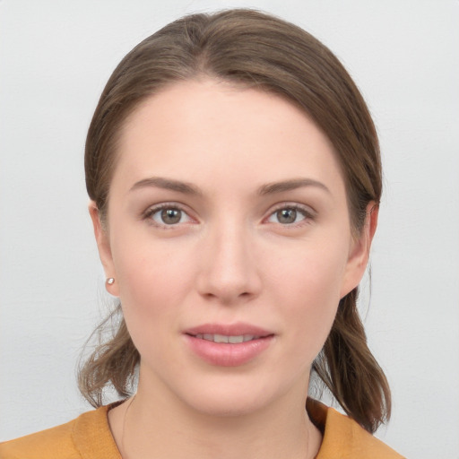 Joyful white young-adult female with medium  brown hair and grey eyes