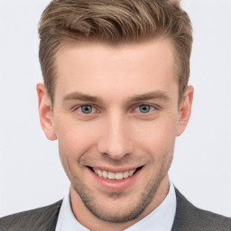 Joyful white young-adult male with short  brown hair and grey eyes