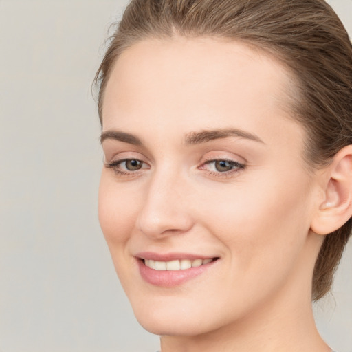 Joyful white young-adult female with medium  brown hair and grey eyes