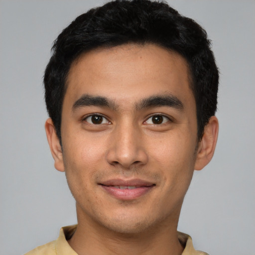 Joyful latino young-adult male with short  black hair and brown eyes