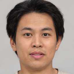 Joyful asian young-adult male with short  brown hair and brown eyes