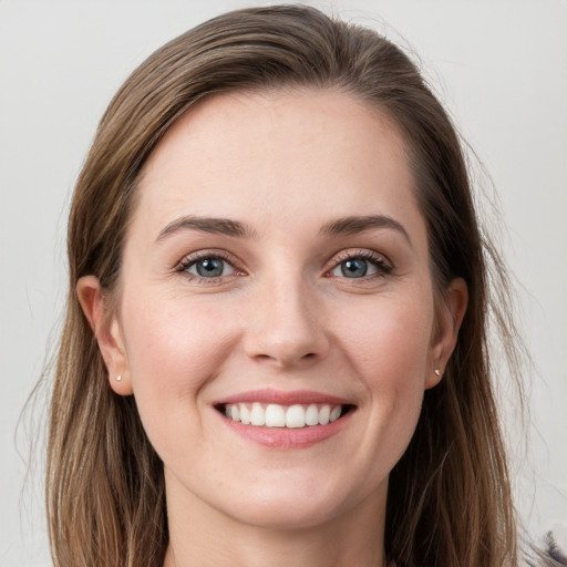 Joyful white young-adult female with long  brown hair and grey eyes