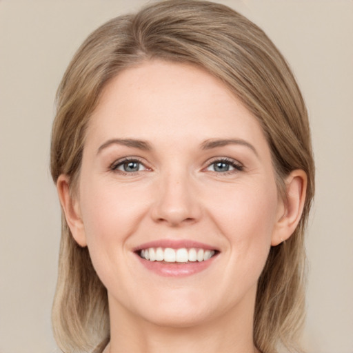 Joyful white young-adult female with long  brown hair and grey eyes