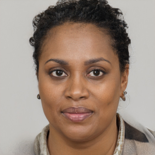 Joyful black adult female with short  brown hair and brown eyes