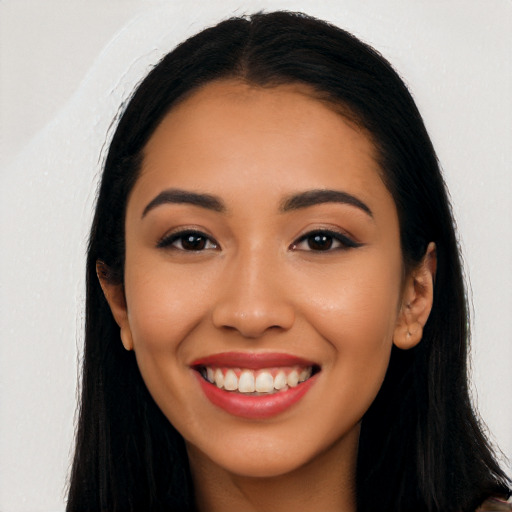 Joyful latino young-adult female with long  black hair and brown eyes