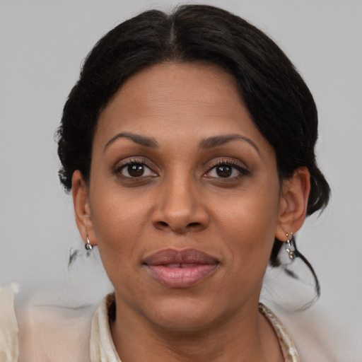 Joyful latino adult female with medium  brown hair and brown eyes