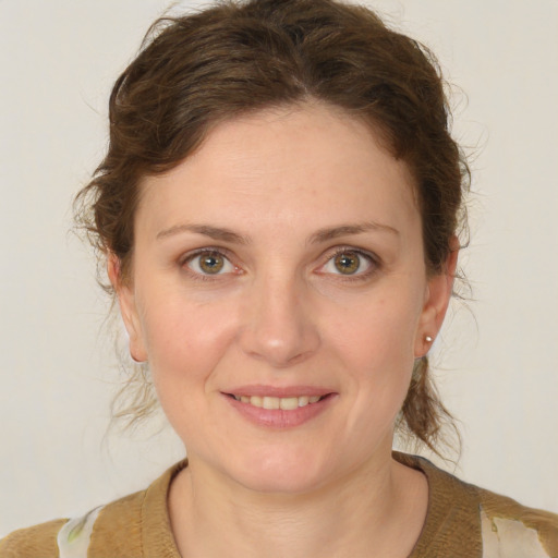 Joyful white young-adult female with medium  brown hair and green eyes