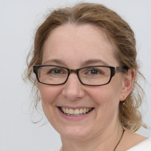 Joyful white adult female with medium  brown hair and blue eyes