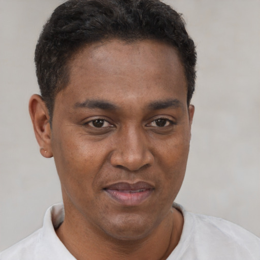 Joyful black young-adult male with short  brown hair and brown eyes