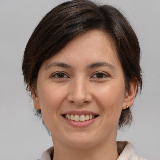 Joyful white young-adult female with medium  brown hair and brown eyes