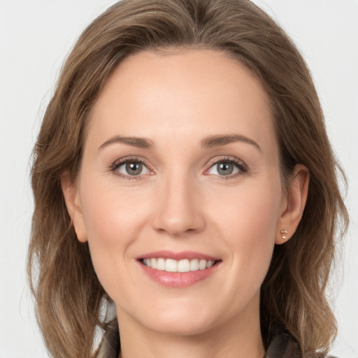 Joyful white young-adult female with long  brown hair and grey eyes