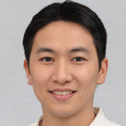 Joyful asian young-adult male with short  brown hair and brown eyes