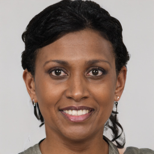 Joyful black young-adult female with short  black hair and brown eyes