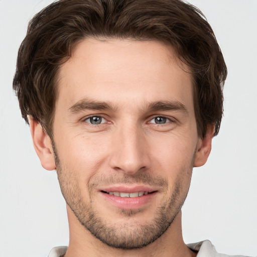 Joyful white young-adult male with short  brown hair and grey eyes