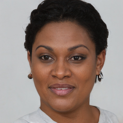 Joyful black young-adult female with short  brown hair and brown eyes