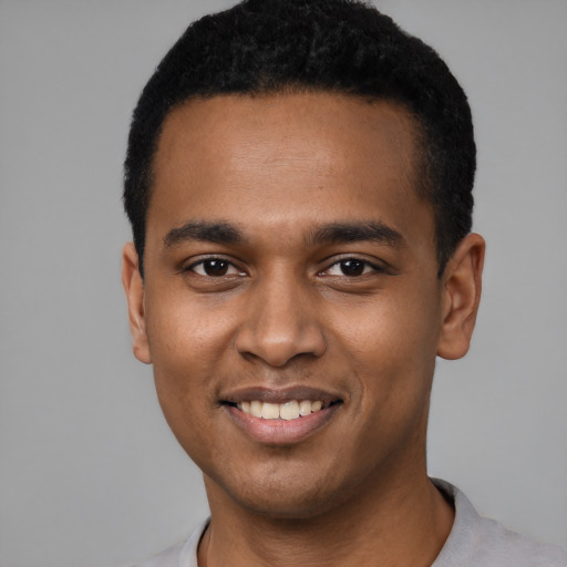 Joyful black young-adult male with short  black hair and brown eyes