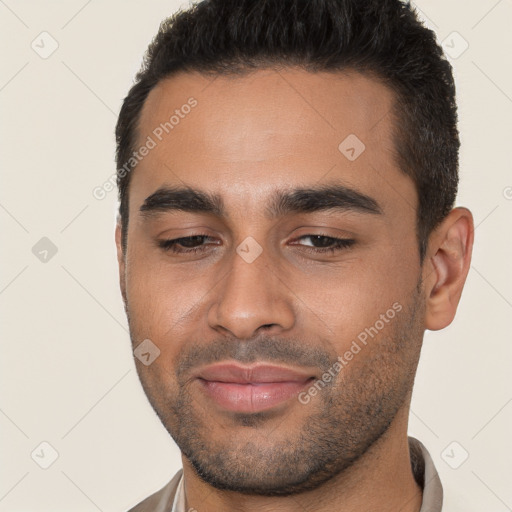 Joyful latino young-adult male with short  black hair and brown eyes