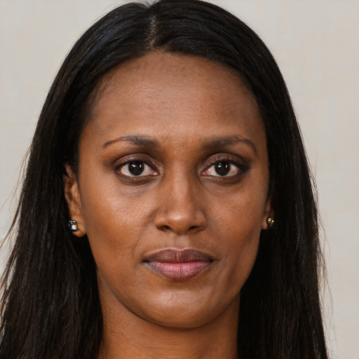 Joyful black young-adult female with long  brown hair and brown eyes